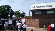 Policemen stand guard as people gather in front of a LG Polymers plant following a gas leak incident in Visakhapatnam on May 7, 2020. AFP 
