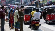 A police officer directs traffic on a road in the central Sri Lankan town of Pilimathalawa May 5, 2020, during a break in the curfew that was first imposed on March 20. AFP / Ishara S. KODIKARA
