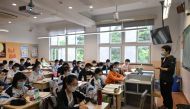 Students wearing face masks are seen in their classroom during a government-organised media tour at Shanghai High School after it reopened in Shanghai on May 7, 2020.   AFP / Hector RETAMAL