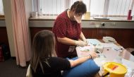 :Michelle van Rooyen (R), a staff member gets ready to take a blood sample from a volunteer at the start of a clinical trial being set up by TASK, a clinical research organisation based in Cape Town, to see whether the Bacillus Calmette-Guerin (BCG) vacci