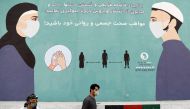 An Afghan man wearing a protective face mask walks past a painted wall during the spread of the coronavirus disease (COVID-19), in Kabul, Afghanistan May 7, 2020. REUTERS/Mohammad Ismail