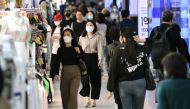 People wearing face masks walk through an underground shopping area in Seoul on May 6, 2020. South Korea returned largely to normal on May 6 as workers went back to offices, and museums and libraries reopened under eased social distancing rules after new 