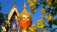 A face mask is placed on the face of a giant Buddha statue at Wat Nithet Rat Pradit temple in Pathum Thani outside Bangkok on May 12, 2020, as the country deals with the COVID-19 novel coronavirus situation.
