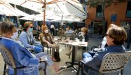 People take a coffee in a bar as some Spanish provinces are allowed to ease restrictions during the phase one, amid the coronavirus disease (COVID-19) outbreak, in Palma de Mallorca, Spain, May 11, 2020. REUTERS/Enrique Calvo
