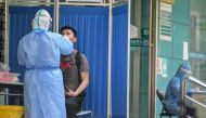 :A medical worker takes a swab sample from a man to be tested for the COVID-19 novel coronavirus in Wuhan, in China’s central Hubei province on May 13, 2020. Wuhan plans to conduct coronavirus tests on the Chinese city's entire population after new cases 