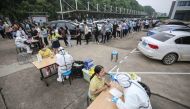 Medical workers take swab samples from staff members from the AOC computer monitor factory to be tested for the COVID-19 coronavirus in Wuhan in China's central Hubei province on May 15, 2020. Nervous residents of China's pandemic epicentre of Wuhan queue