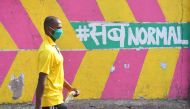 A pedestrian walks past a wall graffiti during a nationwide lockdown imposed as a preventive measure against the spread of the COVID-19 coronavirus, in Mumbai on May 15, 2020. / AFP / INDRANIL MUKHERJEE
