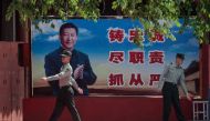 People's Liberation Army (PLA) soldiers are seen next to a poster with a picture of Chinese President Xi Jinping next to the entrance to the Forbidden City in Beijing on May 18, 2020.   AFP / NICOLAS ASFOURI