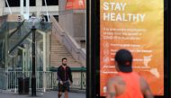 FILE PHOTO: A man walks near an info board following the easing of restrictions implemented to curb the spread of the coronavirus disease (COVID-19), at Darling Harbour near the city centre in Sydney, Australia, May 18, 2020. REUTERS/Loren Elliott/File Ph