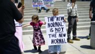 :HARRISBURG, PA - MAY 15: A girl holds a placard stating 