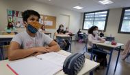 Students, wearing protective face masks, listen to their teacher at the College Sasserno school during its reopening in Nice as a small part of French shoolchildren head back to their schools with new rules and social distancing during the outbreak of the