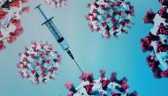 A syringe is pictured on an illustration representation of COVID-19, the disease caused by the novel coronavirus in Paris on May 18, 2020. / AFP / JOEL SAGET
