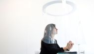 A woman poses under a Plex'Eat prototype plexiglas bubble by designer Christophe Gernigon which surrounds diners to protect them from the novel coronavirus during a presentation in Cormeilles-en-Parisis, near Paris, as restaurants in France prepare to re-
