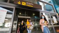 Passengers who were on board a Swiss Air flight from Zurich and who will be put in quarantine arrive at the airport in Valencia on May 21, 2020. / AFP / STR / JOSE JORDAN
