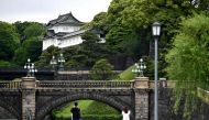 People take pictures of the Imperial Palace, a popular tourist destination, in Tokyo on May 20, 2020. Japan on May 14 lifted a state of emergency imposed due to the coronavirus for the majority of the country but kept it in place for top cities Tokyo and 