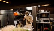 In this picture taken on May 13, 2020 Yuta Shinohara ladles cricket sauce into plastic bags as part of cricket ramen home-cooking kits, at a kitchen in Tokyo. AFP / Behrouz Mehri 