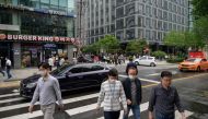 Office workers cross a street during the lunch period in central Seoul on May 22, 2020. / AFP / Ed JONES
