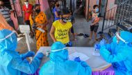 Residents wait for a medical check-up at a screening centre set up inside a slum during a nationwide lockdown to fight the spread of the COVID-19 coronavirus, in Mumbai on May 29, 2020. / AFP / INDRANIL MUKHERJEE