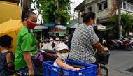 This photo taken on May 25, 2020 shows a child sitting in a plastic box as her mother cycles after receiving food donations for families affected by the COVID-19 novel coronavirus outbreak at the Holy Redeemer Catholic church in Bangkok. AFP / Romeo Gacad