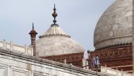 In this picture taken on May 30, 2020, workers stand on the railing of the Taj Mahal after it was damaged due to heavy rainstorm in Agra. / AFP / Pawan Sharma