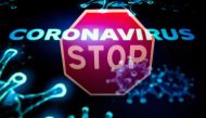 (FILES) This file illustration photo taken on May 10, 2020 in Toulouse shows a stop roadsign reflected on a screen displaying a representation of the novel coronavirus responsible of the COVID-19 disease. / AFP / Lionel BONAVENTURE
