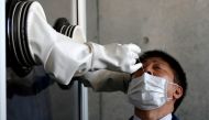 FILE PHOTO: A medical worker conducts a simulation for a walk-in style polymerase chain reaction (PCR) test for the coronavirus disease (COVID-19), at a makeshift facility in Yokosuka, south of Tokyo, Japan, April 23, 2020. REUTERS/Issei Kato/File Photo
