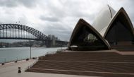 People are seen on the nearly deserted steps of the Sydney Opera House, in the wake of New South Wales in Australia, March 26, 2020. REUTERS/Loren Elliott/File Photo