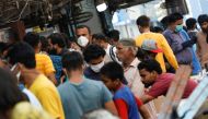 A man wearing a protective face mask walks amidst the rush of people outside an electronics market, after Pakistan started easing the lockdown restrictions, as the outbreak of the coronavirus disease (COVID-19) continues, in Karachi, Pakistan June 4, 2020