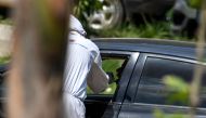 A health official (L) wearing protective gear takes a sample from a man sitting in a car at the drive-through screening and testing facility for the COVID-19 coronavirus alongside a street in Islamabad on June 3, 2020. / AFP / Aamir QURESHI
