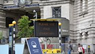 A sign tells passengers to 'wear a face covering' at Waterloo train station in central London , on June 8, 2020, as the UK government's planned 14-day quarantine for international arrivals to limit the spread of the novel coronavirus COVID-19 begins. / AF
