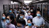 People wearing face masks walk in a subway station during morning rush hour in Beijing on June 8, 2020. / AFP / NOEL CELIS
