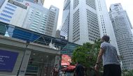 People walk along promenade during lunch break at Raffles Place financial business district in Singapore on June 15, 2020. AFP / Roslan RAHMAN