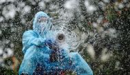 TOPSHOT - A firefighter sprays disinfectant as a preventive measure against the spread of the COVID-19 coronavirus in a containment zone in Chennai on May 11, 2020. / AFP / Arun SANKAR

