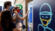 People wearing protective face masks choose seats at UCI Cinemas as Italy eases some of the lockdown measures put in place during the coronavirus disease (COVID-19) outbreak, in Rome, Italy June 15, 2020. REUTERS/Yara Nardi
