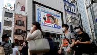 A large screen on a building shows live broadcast of Japan's Prime Minister Shinzo Abe's news conference in Tokyo, Japan May 25, 2020. REUTERS/Issei Kato/File Photo