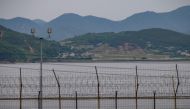 A general view shows the skyline of North Korea behind the barbed-wire fence of the Demilitarized Zone (DMZ) separating North and South Korea, on the South Korean island of Gyodong on June 18, 2020.   AFP / Ed JONES
