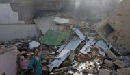 A man stands on the debris of a house at the site of a passenger plane crash in a residential area near an airport in Karachi, Pakistan May 22, 2020. REUTERS/Akhtar Soomro
