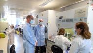 Britain's Prince William, Duke of Cambridge (2L), wearing PPE (personal protective equipment), of a face mask or covering, eye protection and an overall as a precautionary measure against spreading COVID-19, meets scientists including Christina Dold (R) d