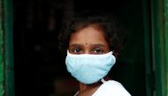 A girl wears a protective face mask in a slum area, during an extended nationwide lockdown to slow the spreading of the coronavirus disease (COVID-19), in New Delhi, India, June 24, 2020. REUTERS/Adnan Abidi