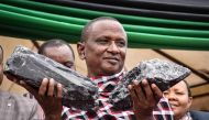 Tanzanian small-scale miner Saniniu Kuryan Laizer, 52, poses with two of the biggest of the country's precious gemstones, Tanzanite, as a millionaire during the ceremony for his historical discovery in Manyara, northern Tanzania, on June 24, 2020. AFP / F