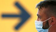 A passenger wearing a protective face mask waits for his flight at Fiumicino Airport, one of the two airports in the world to obtain the 'Biosafety Trust certification' for the correct application of security measures to prevent infections, following the 