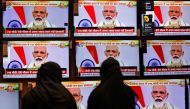 Women watch Indian Prime Minister Narendra Modi address the nation amid the spread of the coronavirus disease (COVID-19), on TV screens inside a showroom in Ahmedabad, India, June 30, 2020. REUTERS/Amit Dave
