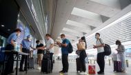 Station staff wear protective gear as they check the ID and health status of travellers before they enter the Beijing South Railway Station, after an outbreak of the coronavirus disease (COVID-19), in Beijing, China July 3, 2020. REUTERS/Thomas Peter
