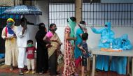 People stand in a queue as a healthcare worker checks the temperature of a resident using an electronic thermometer during a medical campaign for the coronavirus disease (COVID-19) in Mumbai, India, July 4, 2020. REUTERS/Francis Mascarenhas
