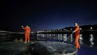 Workers of Yibin waterway bureau adjust a buoy on the Yibin section of the Yangtze River, whose water level has risen following heavy rainfall, in Yibin, Sichuan province, China July 2, 2020. Picture taken July 2, 2020. China Daily via Reuters 