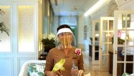 A waitress wearing a protective mask and face shield reacts at the Mandarin Oriental hotel, after the government eased some protective measures following the coronavirus disease (COVID-19) outbreak, in Bangkok, Thailand July 7, 2020. REUTERS/Jorge Silva
