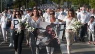 Veronique Monguillot (C), wife of bus driver Philippe Monguillot, declared brain dead after being attacked for refusing to let aboard a group of people who were not wearing face masks, holds a picture of her husband during a white march in Bayonne, southw
