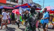 In this file photo taken on April 21, 2020, a member of the Philippine National Police Special Action Forces uses a megaphone to remind shoppers to practice social distancing during a government imposed enhanced quarantine as a preventive measure against 