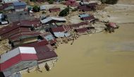 This aerial handout picture taken and released on July 17, 2020 by Indonesian mitigation management agency (BNPB) shows houses buried in mud in North Luwu, South Sulawesi, after several rivers burst their banks following torrential rains in the region./ A