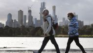 People walk along Albert Park lake in Melbourne on July 13, 2020, as five million people in Australia's second-biggest city began a new lockdown following a resurgence of coronavirus cases. / AFP / William WEST
